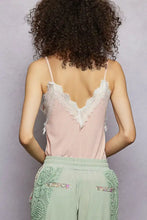 A delicate pink pol lace cami tank with a white lace v-neckline and frayed edges in ribbed fabric