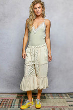 The model wears a light green pol lace ribbed cami with lace trim paired with an off-white patchwork skirt with embroidery