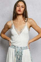 White lace-trimmed pol lace neck ribbed cami in a spaghetti strap design with v-neck detail