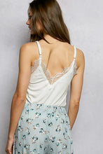 White lace-trimmed pol lace neck ribbed cami with delicate frayed edges and thin straps in a camisole style