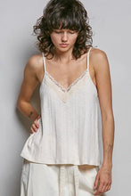 A delicate off-white textured knit cami with lace-trimmed v-neckline and spaghetti straps for elegant layering
