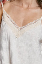 Off-white textured knit cami with lace trim v-neckline and delicate spaghetti straps in a soft ribbed fabric