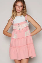 Pink denim overall dress with lace patchwork, silver buttons, tiered design, and adjustable straps by POL