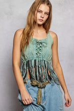 A light green lace-up fringe hem tank with front lacing detail and black and white fringe trim
