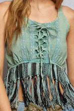 A mint green lace-up halter fringe hem tank with black and teal fringe detailing and lace detail