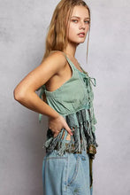 A sage green POL lace-up fringe hem tank with tie-front design and distressed denim accents
