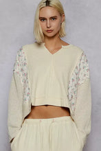 Cream-colored quilted knit cropped top with ribbed body and floral-patterned sheer sleeves for best fit
