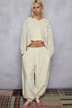 Cream-colored quilted knit crop top with patchwork and floral embroidery on sleeves offering best fit style