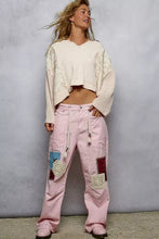 Pink corduroy pants with patchwork crocheted and embroidered squares paired with a quilted knit floral pattern cropped top with raw edge detail