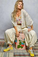 Pink POL Open crochet cardigan with floral embroidery on stool