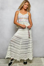 White crochet maxi skirt with intricate lace detailing and patterned belt paired with pol printed contrast cami featuring blanket stitch trim detail