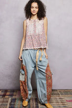 Light blue denim cargo pants with warm earth tone patchwork panels paired with pol printed woven lace back sleeveless top