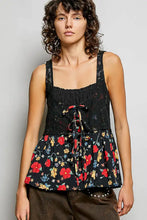 Black ribbed sleeveless top with lace bust paired with floral woven patch skirt featuring red yellow and blue flowers