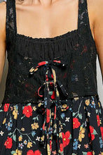 Black floral print dress with lace straps and tied bow at waist featuring a floral woven patch detail