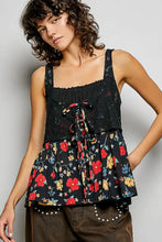 Black floral print peplum top with lace detailing and tied waistband featuring a floral woven patch design