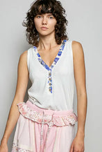White ribbed sleeveless tank top with blue contrast floral neckband and button details for casual wear