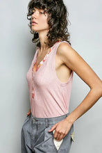 A soft pink ribbed knit sleeveless top with a contrast floral neckband and subtle floral pattern along the neckline