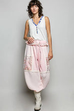 A soft pink patchwork harem pant with lace trim and sequined pockets paired with a contrast floral neckband tank