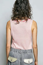 A soft pink ribbed knit sleeveless top with a contrast floral neckband and subtle textured pattern
