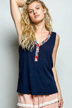 Navy blue ribbed knit sleeveless top with contrast floral neckband featuring colorful floral pattern placket