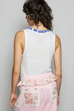 White ribbed sleeveless tank top featuring a blue contrast floral neckband and textured fabric design