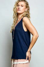 Navy blue ribbed knit sleeveless top with contrast floral neckband featuring colorful embroidery at the neckline