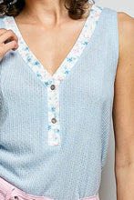 Light blue ribbed knit sleeveless top with contrast floral neckband v-neck and button placket detail