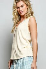 Cream-colored sleeveless ribbed knit tank with textured weave and subtle side zipper featuring contrast floral neckband
