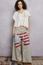Pol short sleeve hooded top with back-open detail paired with patchwork wide-leg cotton trousers featuring american flag accents