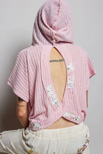 Pink ribbed pol short sleeve hooded top with floral patchwork details on the back and sides showing back view