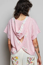 A soft pink pol short sleeve hooded top with ribbed knit fabric and floral back panel shown from the back side