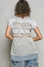 Back view of a layered off-white and denim subtle stripe pattern cross-back string top with lace and center tie detail