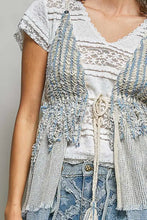 A distressed light blue and white crochet cardigan with frayed edges and a subtle stripe pattern center tie