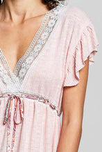 A soft pink short sleeve blouse with v-neckline, white lace detail, and fluttery lightweight fabric for elegant wear