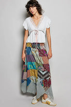 A pol tied ruffled v-neck short sleeve blouse with lace detail paired with a colorful patchwork maxi skirt