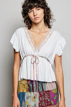 White short sleeve blouse with lace trim and tied waistband in a polished v-neck design