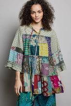 A vibrant pol tiered floral patchwork tie neck shirred ruffled blouse made from colorful floral and striped fabrics