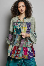 A pol tiered floral patchwork blouse with colorful ruffled sleeves and layered tiers in green purple pink and blue