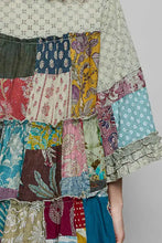 A pol tiered floral patchwork blouse made of vintage fabrics with ruffled sleeves and a layered hem in muted tones