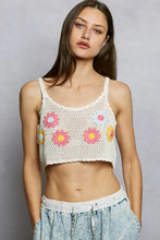 White crocheted crop top with colorful floral embroidery in pink yellow and blue featuring u-neck design and cropped crochet cami style