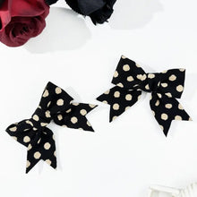 Polka dot bow hair clip set with two black bows and cream dots