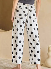 White denim high-waisted jeans featuring black polka dots and a relaxed wide-leg cut for casual wear
