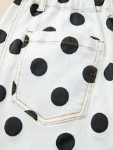 Polka dot high-waisted white denim shorts with black polka dots and tan stitching for a stylish casual look