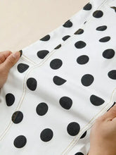White high-waisted denim shorts with black polka dots and contrasting stitching in a polka dot design