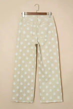 Cream-colored high-waisted wide leg jeans featuring a white polka dot pattern for stylish casual wear