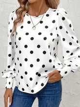 White long sleeve blouse with black polka dots and smocked cuffs in a polka dot long sleeve design