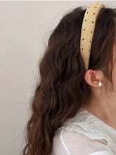Polka dot polyester wide headband with wavy dark brown hair and white pearl earring