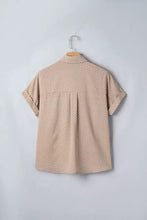 Beige short sleeve blouse with white polka dots hanging on wooden hanger showcasing polka dot print short sleeve shirt