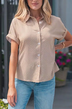 Beige short-sleeved button-up blouse with white polka dots featuring a lightweight breathable fabric for casual wear