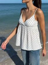 Polka dot v neck flowy cami with white fabric, thin straps, and gathered waist for a stylish summer look